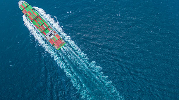 istock Aerial view of container cargo ship sailing through deep blue ocean, leaving waves behind. Perfect for concepts of maritime logistics, global shipping, export-import trade, and sea freight transport. 2243754077