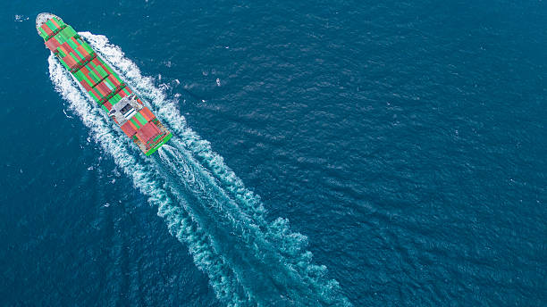 istock Aerial view of container cargo ship sailing through deep blue ocean, leaving waves behind. Perfect for concepts of maritime logistics, global shipping, export-import trade, and sea freight transport. 2243754354
