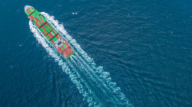 istock Aerial view of container cargo ship sailing through deep blue ocean, leaving waves behind. Perfect for concepts of maritime logistics, global shipping, export-import trade, and sea freight transport. 2243755083