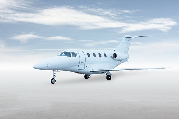 istock Modern white private jet isolated on bright background with sky 2243759957
