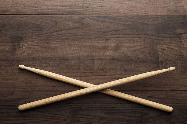 Flat lay top down photo of pair of wooden drumsticks on wooden table with copy space.