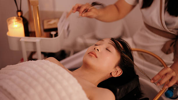 istock Asian woman relaxing as a spa therapist gently stimulates her face with feathers during a tactile therapy session 2243762409