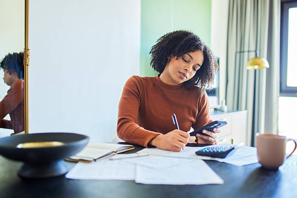istock Focused Black Woman Working on Budget and Writing Notes at Home Desk 2243763332