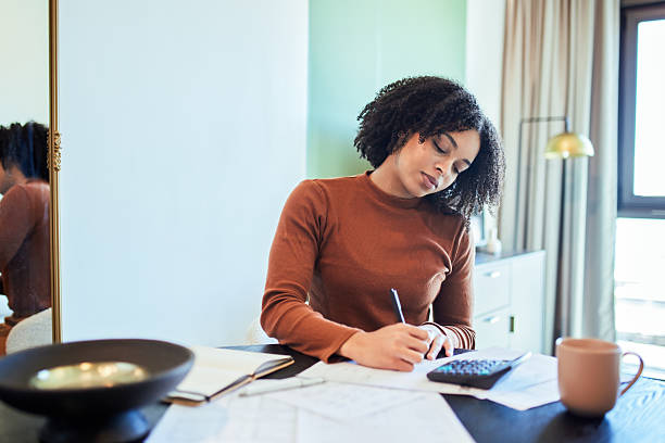 istock Focused Black Woman Working on Finances with Calculator and Paperwork 2243763389