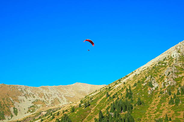 Paraglider (speed flier) soars over Swiss Alps