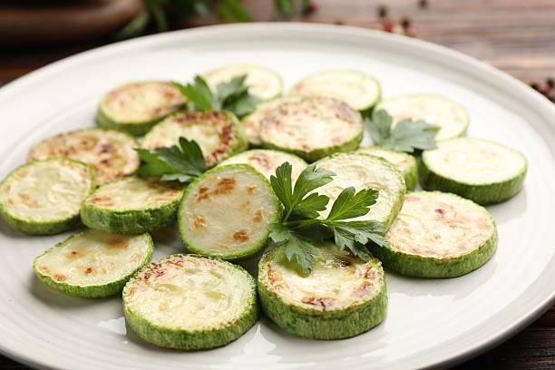 istock Delicious fried courgette slices with parsley on table, closeup 2243763864