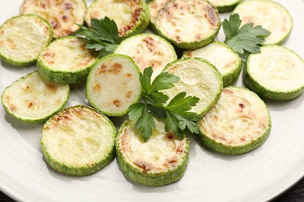 istock Delicious fried courgette slices with parsley on plate, closeup 2243763947