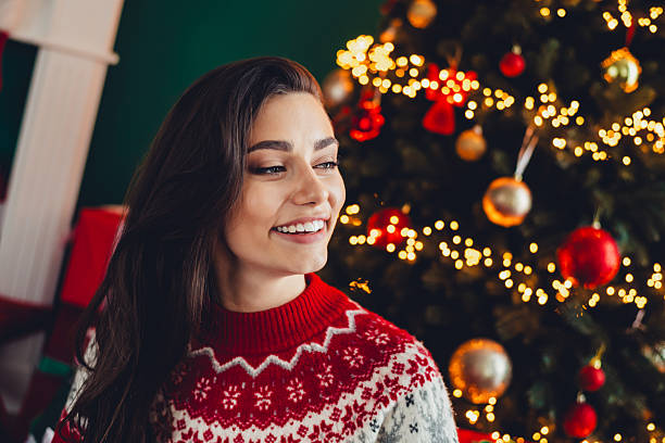 istock Bright festive smile beside christmas tree wearing red and white sweater in cozy home setting during holidays 2243764228