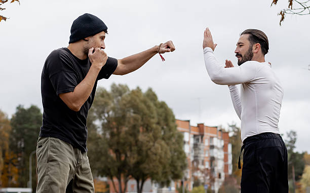 istock Two young men practicing martial arts outdoors in city park, training self-defense techniques on a cloudy day 2243769677