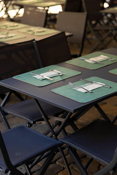 istock Empty outdoor restaurant tables with placemats and cutlery set 2243769821