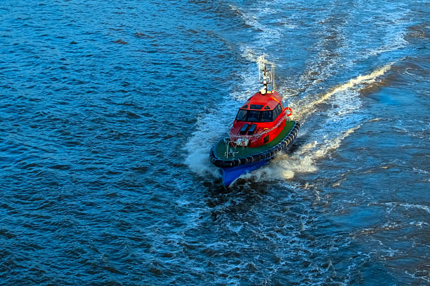 Pilot boat moving at speed on the sea escorting a cruise ship.