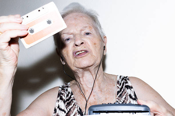 Close-Up Of Senior Man Playing Harmonica At Home