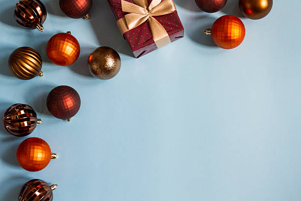 istock Festive Christmas ornaments and gift box arranged on a light blue background 2243770672