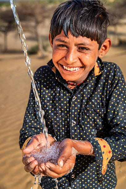 istock Indian young boy drinking fresh water, desert village, Rajasthan, India 2243773607