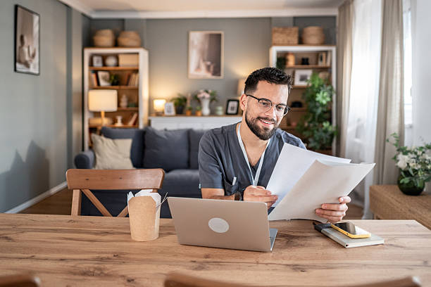 istock Doctor or nurse working from home with documents and laptop 2243774435