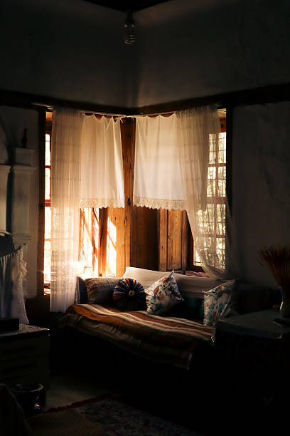 istock Warm Sunlight on a Comfortable Window Seat with Colorful Cushion 2243774483