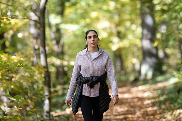 istock Woman hiking forest path during autumn 2243776126