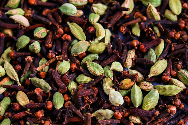 Aromatic spices background: cardamom and clove