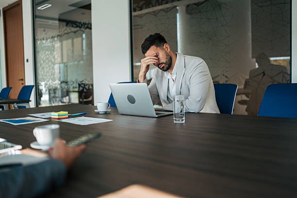 istock Businessman feeling stress and burnout in office meeting 2243777683