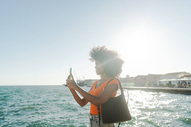 istock Female tourist capturing an image with mobile phone while on a city break vacation 2243777758