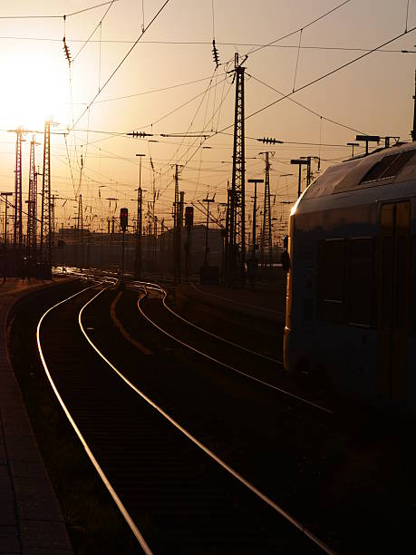 istock Train is traveling down a track with a sunset in the background 2243783986