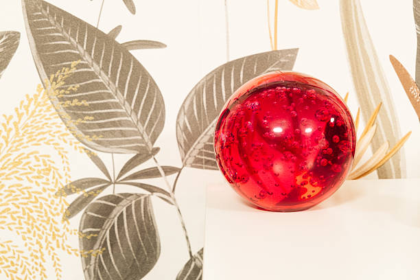 Decorative red glass ball on the edge of a table.