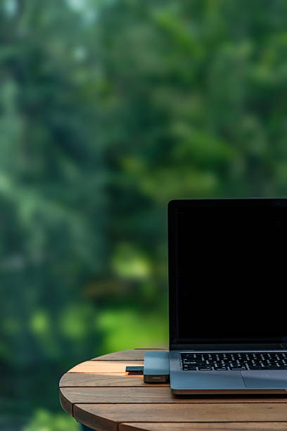istock laptop on wooden table connect with memory card reader inserted by camera memory card with ray of sun light spotted on it 2243786248