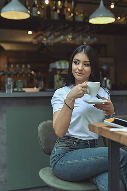 Young Woman Enjoying Coffee At Modern Lounge Bar During Breakfast