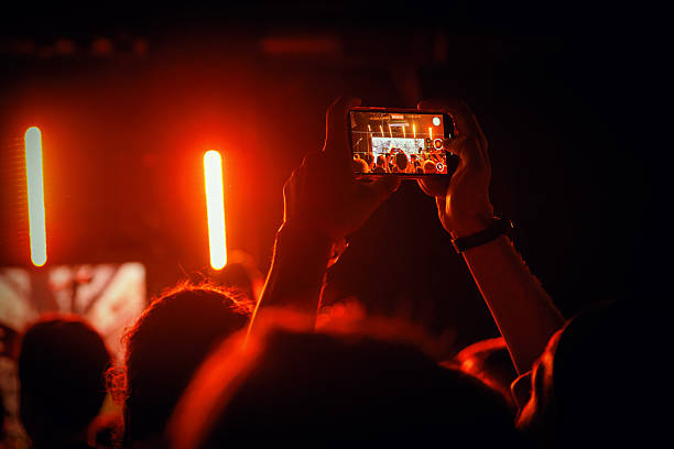 istock Smartphone capturing concert under orange stage lighting 2243788525