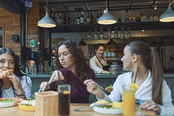 istock Female Bartender Working and Listening to Three Friends Who Enjoy Breakfast 2243788562