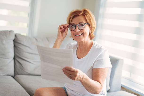 istock mature senior woman check bill on sofa 2243788652