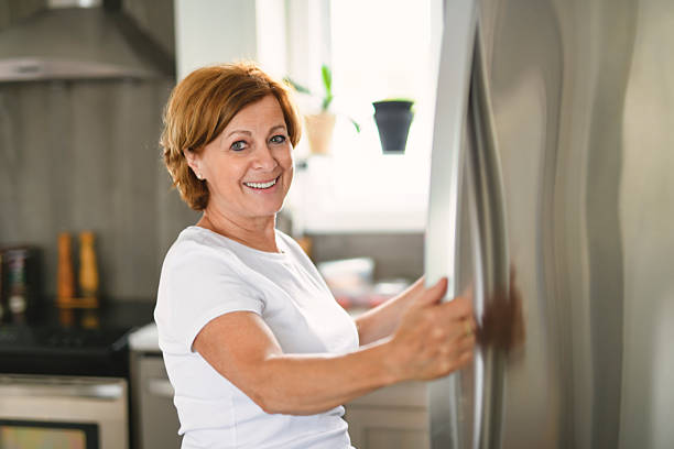 istock Happy woman near open refrigerator in kitchen. 2243788807