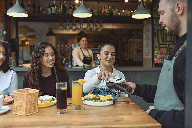 istock Friends Enjoy Breakfast At Modern Lounge Bar With Quick Payment Service And Food Experience 2243790733