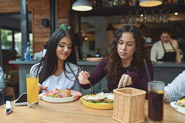 istock Friends Enjoy Breakfast At A Modern Lounge Bar With Pastries And Cold Drinks 2243790999