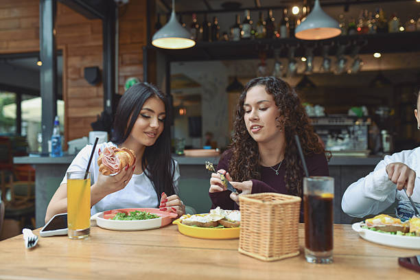 istock Friends Enjoy Breakfast At A Modern Lounge Bar With Pastries And Cold Drinks 2243791018