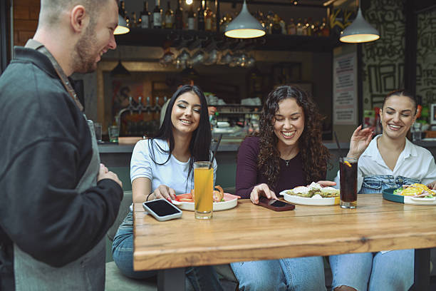 istock Friends At A Modern Lounge Bar Enjoying Breakfast, Drinks, And Laughter Together 2243791350