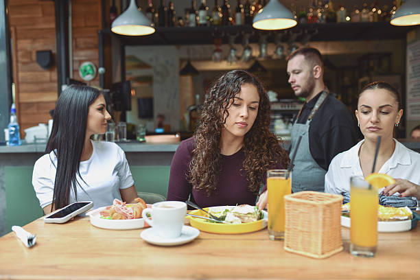 Friends At A Modern Bar Breakfast Shared Among Three Women At A Bright Table