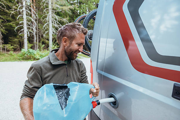 istock Man Refilling Camper Van Water Tank Outdoors 2243792086