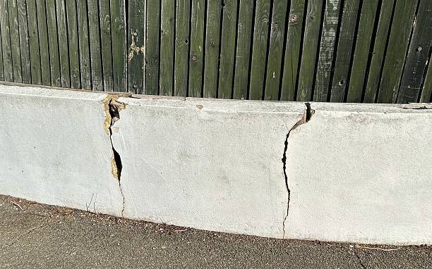istock Cracked white wall with fence 2243792779