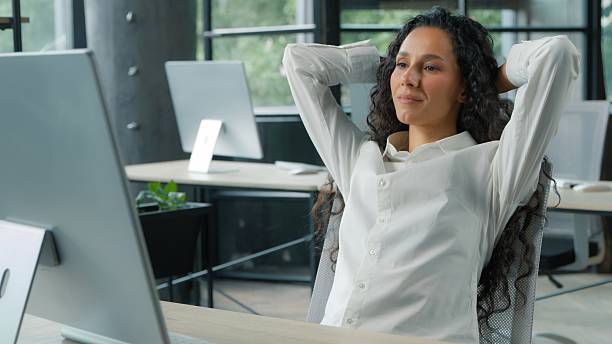 istock Hispanic business woman in office working computer finish relaxing putting hands behind head manager businesswoman typing pc complete job online resting break pause carefree female worker job done 2243797440