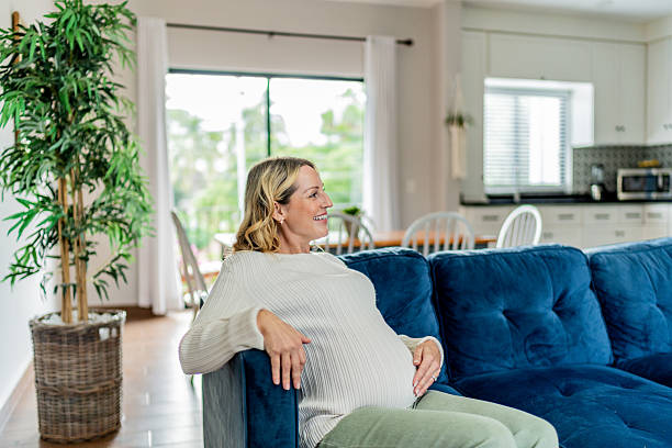 istock Happy mid adult pregnant touching belly at home 2243798310