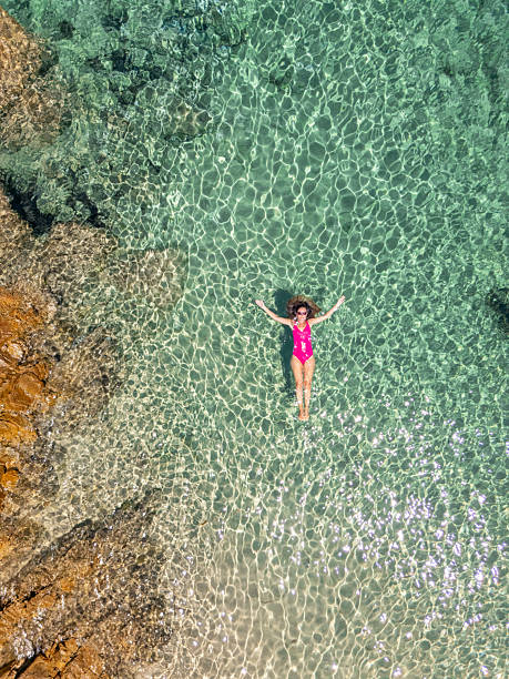 istock Woman Floating Relaxed in Clear Shallow Water 2243800500