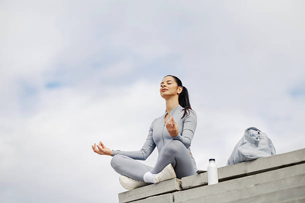 Young woman meditating outdoors finding inner peace stock photo