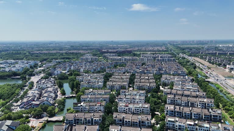 Aerial photo of modern town with white buildings, green spaces and water features in residential development