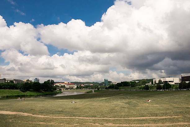 Vilnius, Lithuania - July 01, 2015 - Sunny park day under cloudy blue sky with scenic city view.