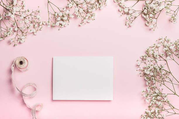 istock Flat lay composition with paper card, gypsophila and openwork ribbon on a pink background. Postcard. Invitation to a wedding or women's birthday. Stylish women's workplace. 2243806939