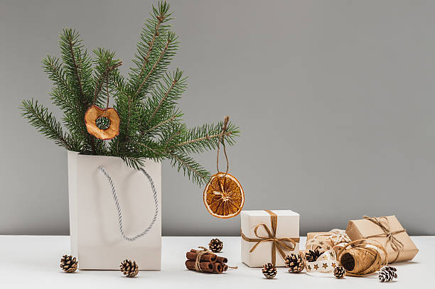 istock Fir branches decorated with dried orange and apple slices, Christmas gift boxes in eco craft packaging. Natural materials and textures in Christmas decor, eco-Christmas holiday. 2243807002