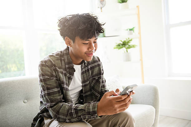 istock thai teen using cellphone at home sofa 2243812019