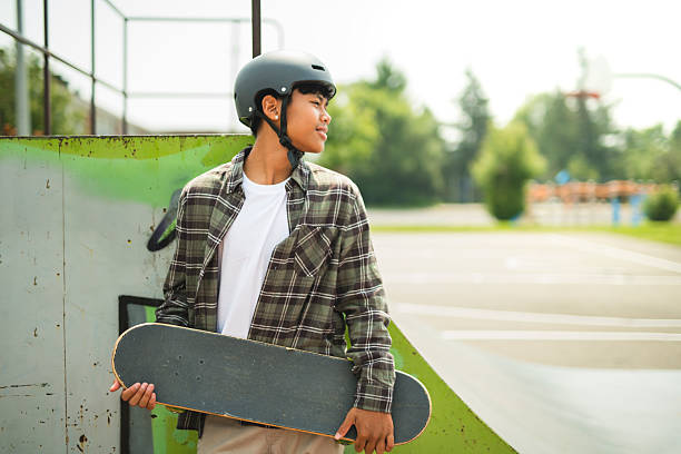 A nice Boy with skateboards outside on skate playground