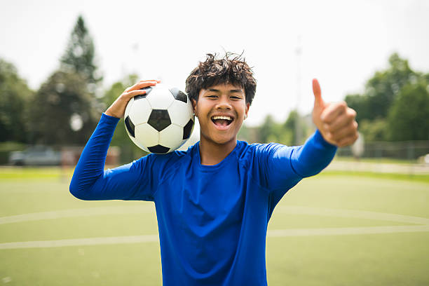 A nice Boy with soccer ball outside on field